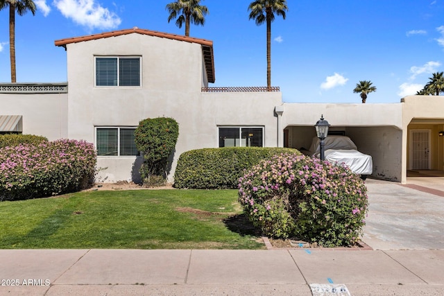 view of front facade featuring a front yard, a tiled roof, and stucco siding