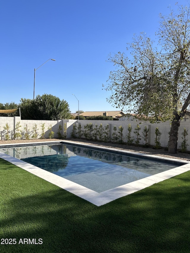 view of pool with a lawn