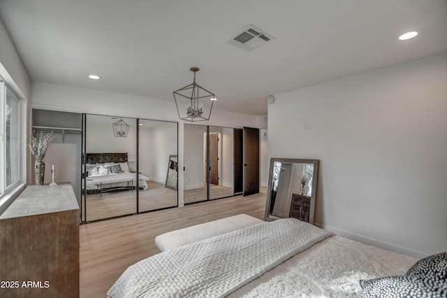 bedroom featuring light hardwood / wood-style flooring and an inviting chandelier