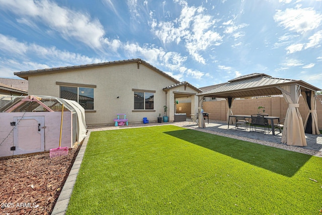 19946 W Glenrosa Ave, Litchfield Park, AZ 85340 - rear view of house featuring a gazebo, stucco siding, a fenced backyard, a lawn, and a patio