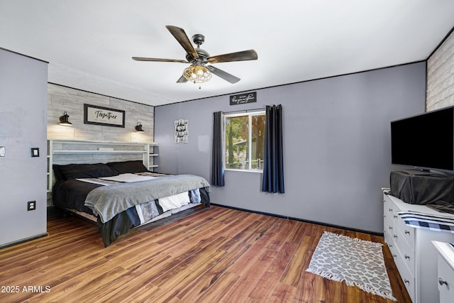 2921 N 103rd Ave, Avondale, AZ 85392 - bedroom featuring wood finished floors, an accent wall, ceiling fan, and wood walls