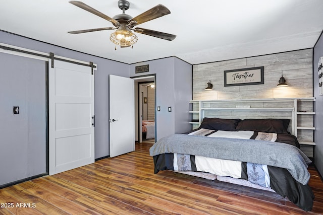 2921 N 103rd Ave, Avondale, AZ 85392 - bedroom with wood finished floors, a barn door, and a ceiling fan