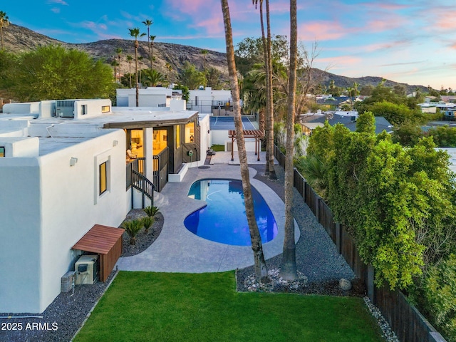 908 W Pershing Ave, Phoenix, AZ 85029 - pool at dusk with a fenced backyard, a mountain view, and a patio