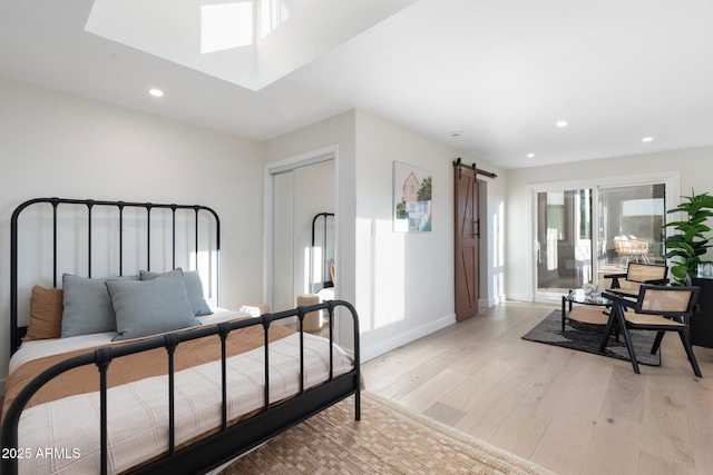 908 W Pershing Ave, Phoenix, AZ 85029 - bedroom featuring a barn door, light wood-style floors, recessed lighting, a skylight, and a closet