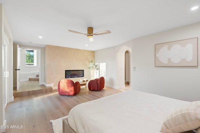 908 W Pershing Ave, Phoenix, AZ 85029 - bedroom featuring arched walkways, light wood-style flooring, recessed lighting, a ceiling fan, and a large fireplace
