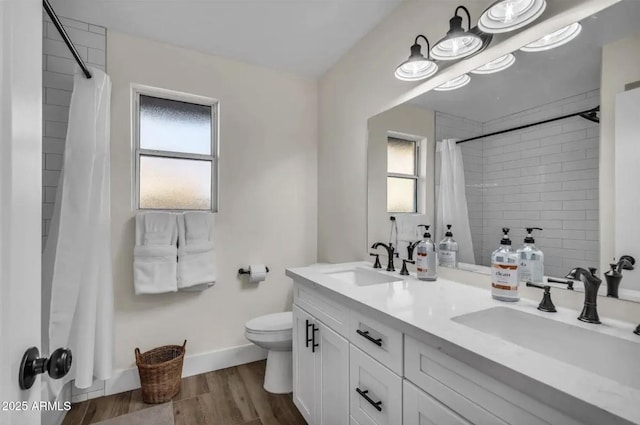 bathroom with vanity, toilet, a healthy amount of sunlight, and wood-type flooring