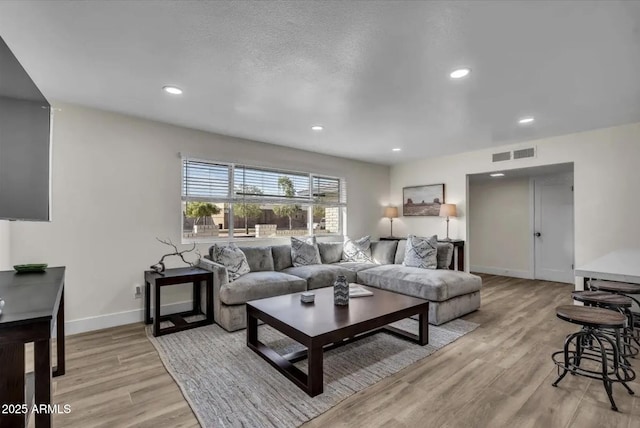 living room featuring a textured ceiling and light wood-type flooring