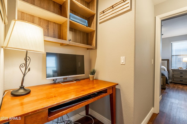 office with baseboards, dark wood finished floors, and built in study area