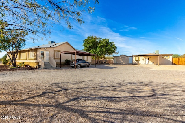 exterior space with a carport and a storage unit