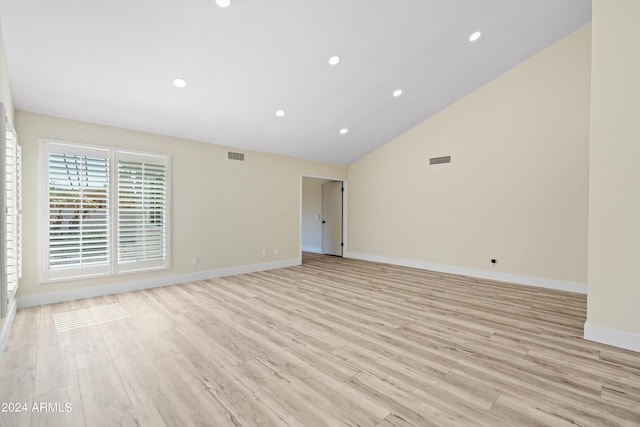 spare room with light hardwood / wood-style floors and high vaulted ceiling