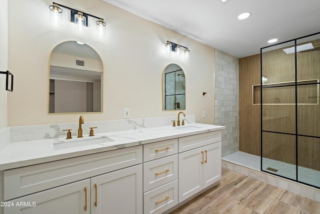 bathroom featuring vanity, hardwood / wood-style flooring, and tiled shower