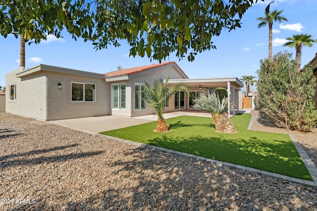 rear view of property with a lawn and a patio