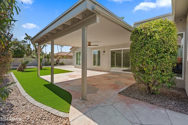 back of property featuring ceiling fan and a patio