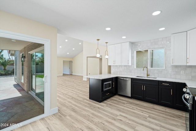 kitchen featuring light wood-type flooring, sink, white cabinets, hanging light fixtures, and stainless steel appliances