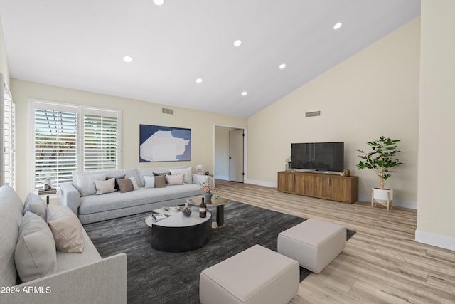 living room with high vaulted ceiling and light wood-type flooring