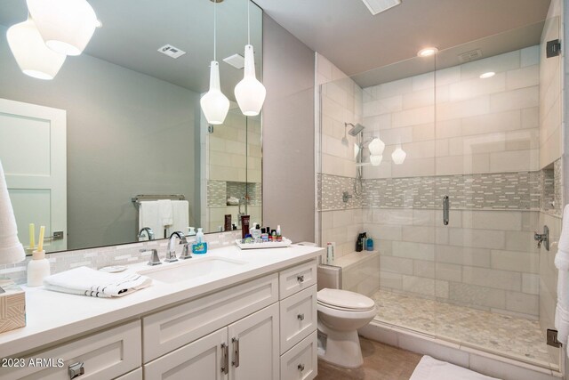 bathroom with vanity, toilet, and a shower with door