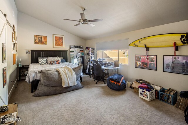 carpeted bedroom featuring lofted ceiling, a barn door, and ceiling fan