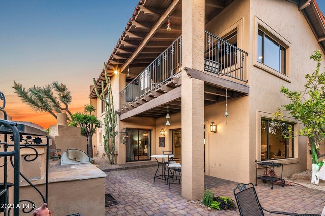 exterior space featuring an outdoor kitchen and a balcony