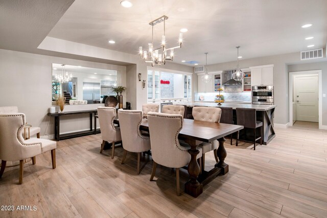 dining area featuring light hardwood / wood-style flooring and a chandelier