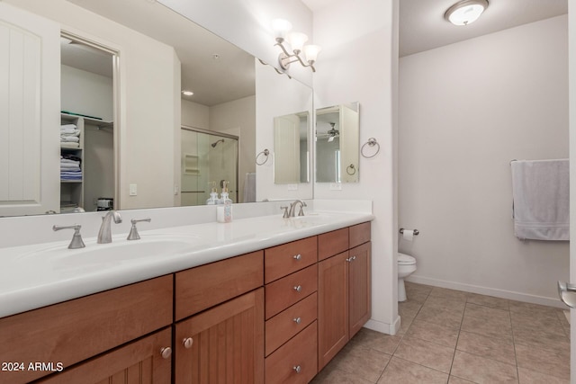 bathroom with a shower with door, tile patterned flooring, vanity, and toilet