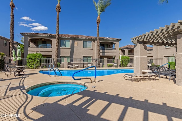 view of swimming pool featuring a community hot tub, a pergola, and a patio