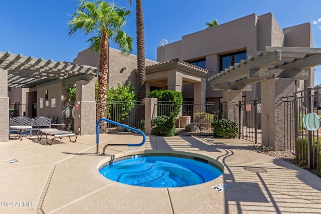 view of swimming pool with a community hot tub, a pergola, and a patio area