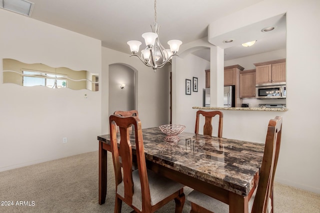 dining area featuring light colored carpet and a chandelier