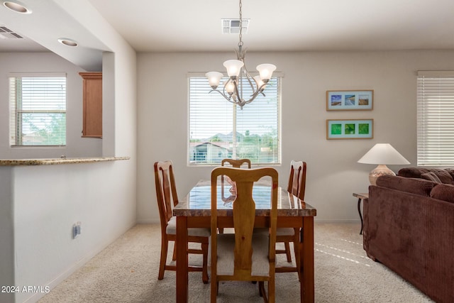 dining area with a notable chandelier and light carpet