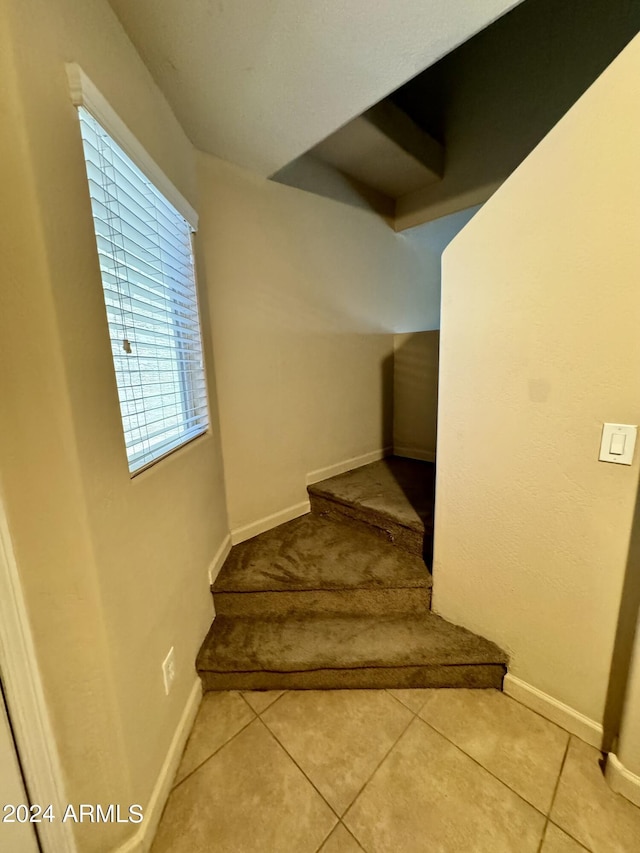 stairway featuring tile patterned flooring