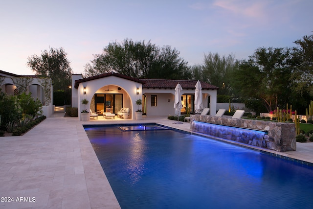 pool at dusk featuring a patio