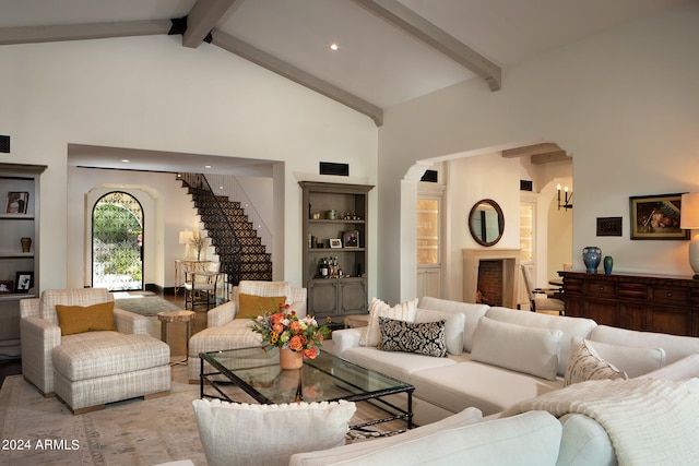 living room featuring beam ceiling and high vaulted ceiling