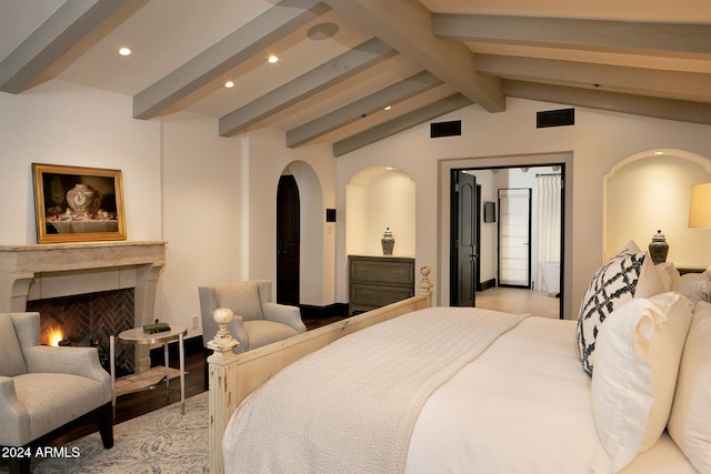 bedroom with vaulted ceiling with beams and light hardwood / wood-style floors