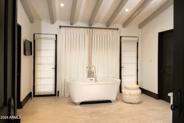 bathroom with vaulted ceiling with beams and a bath