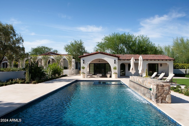 view of swimming pool featuring pool water feature and a patio