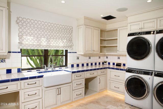 washroom with stacked washer / drying machine, sink, and washing machine and clothes dryer