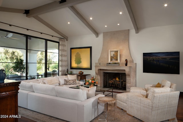 living room featuring vaulted ceiling with beams, a tiled fireplace, and wood-type flooring