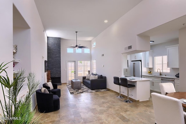 11333 N 92nd St Unit 1118, Scottsdale, AZ 85260 - living area featuring ceiling fan, plenty of natural light, a towering ceiling, and light stone finish floors