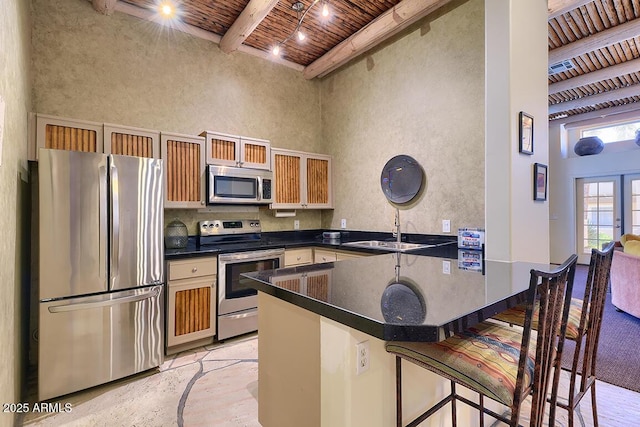 11333 N 92nd St Unit 1118, Scottsdale, AZ 85260 - kitchen with appliances with stainless steel finishes, a peninsula, a wood ceiling with exposed beams, dark countertops, and a high ceiling