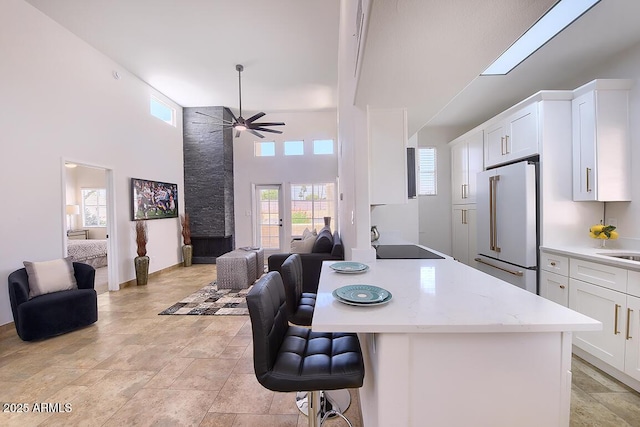 11333 N 92nd St Unit 1118, Scottsdale, AZ 85260 - kitchen featuring high end white refrigerator, open floor plan, a breakfast bar, healthy amount of natural light, and a towering ceiling