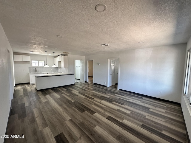 1214 E Henry St, Tempe, AZ 85288 - unfurnished living room with dark wood-style flooring, a textured ceiling, baseboards, and a sink