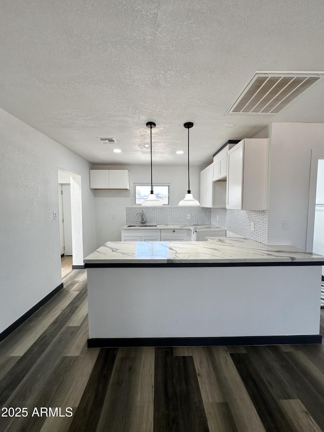 1214 E Henry St, Tempe, AZ 85288 - kitchen featuring a sink, dark wood finished floors, white cabinetry, tasteful backsplash, and a textured ceiling