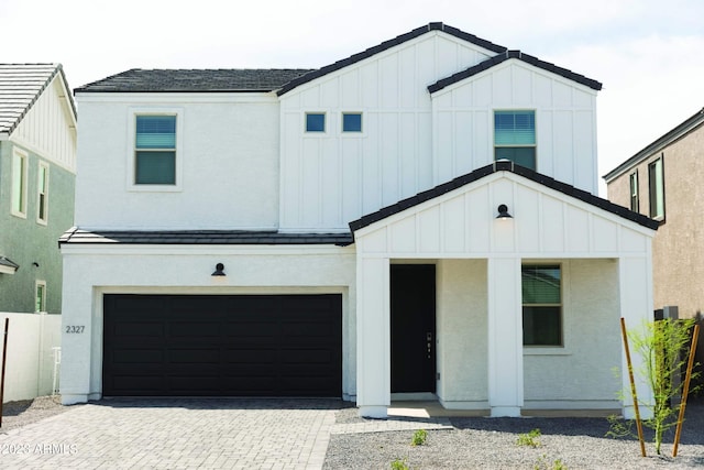 modern inspired farmhouse featuring board and batten siding, a garage, decorative driveway, and a standing seam roof