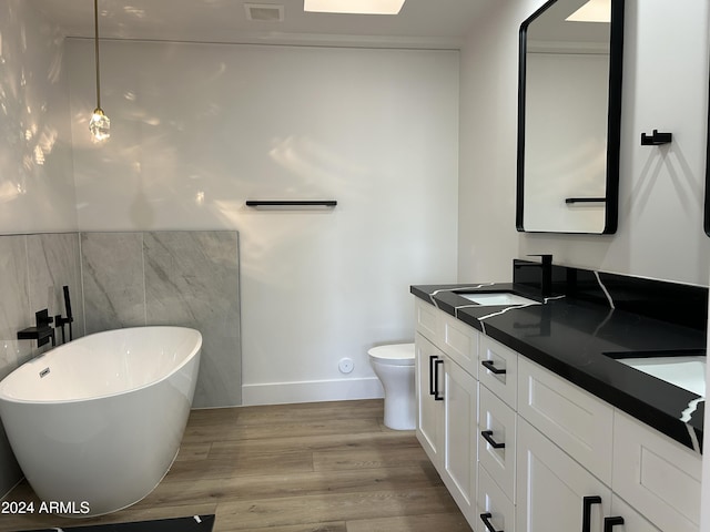 bathroom with vanity, wood-type flooring, toilet, and a bathing tub