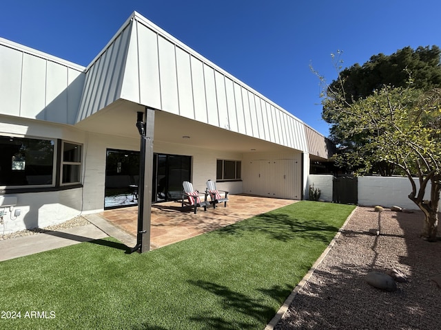 back of house featuring a patio and a lawn