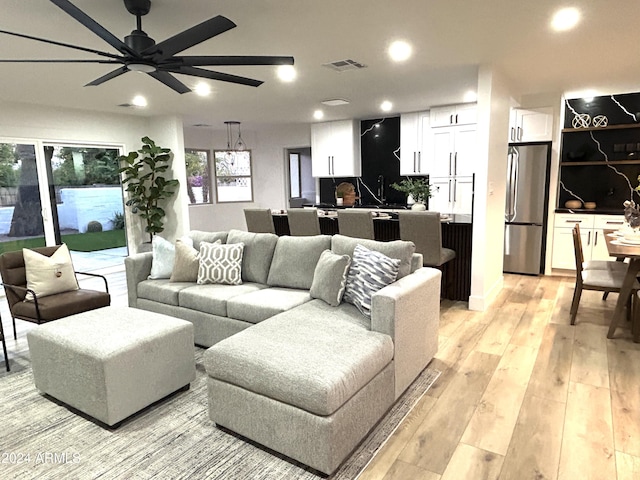 living room featuring light hardwood / wood-style floors and ceiling fan