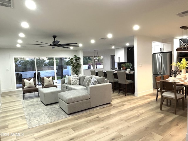 living room featuring ceiling fan and light hardwood / wood-style floors