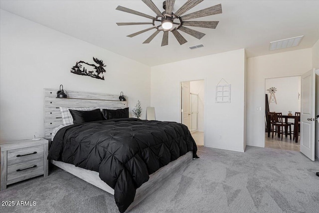 bedroom with ensuite bathroom, ceiling fan, and light colored carpet