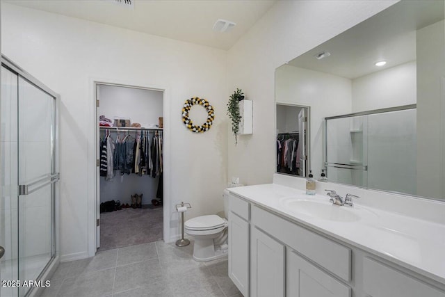 bathroom with toilet, tile patterned flooring, a shower with door, and vanity