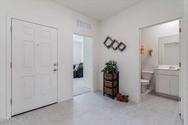 foyer featuring light tile patterned flooring and sink