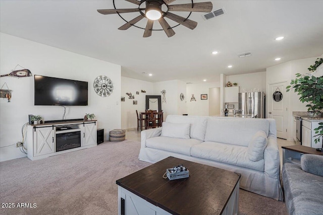 carpeted living room featuring ceiling fan